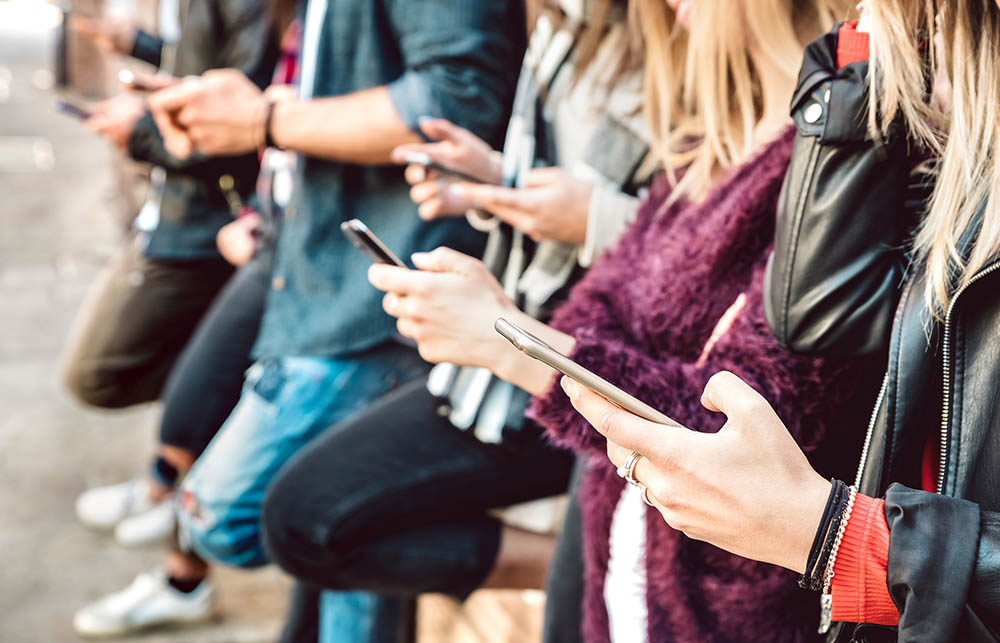 Shallow view of friends hands sharing content on mobile cell pho